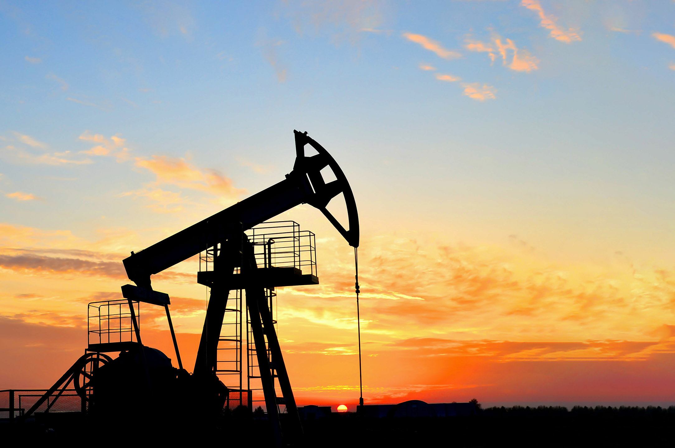 Oil drilling derricks at desert oilfield. Crude oil production f